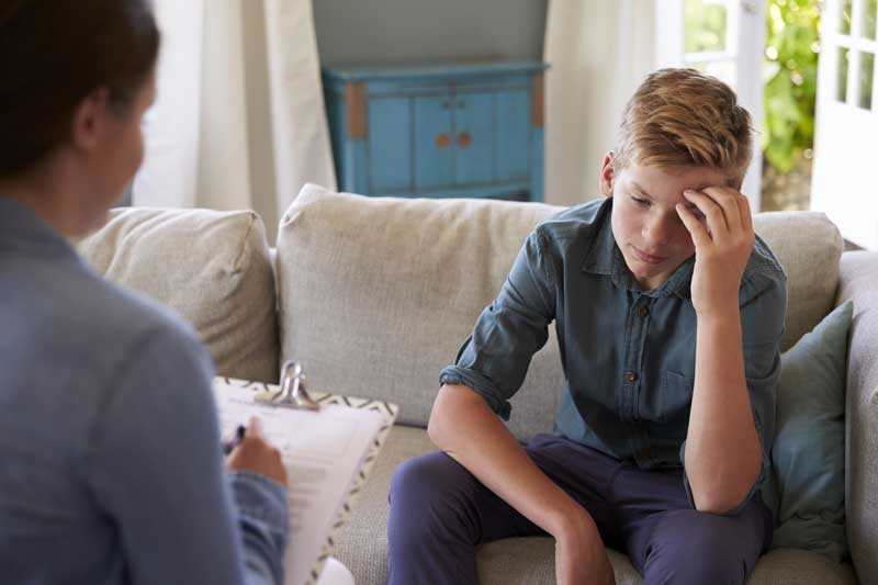 teenage boy with problem talking with counselor at home